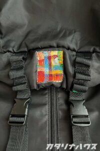 リュックの剥がれかけたタグをカラフルな刺繍糸でバスケットダーニングしている様子。