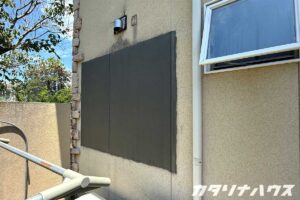 外壁にあいた穴を塞ぎ、左官で補修している外観写真。