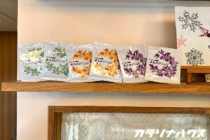 ３種類のカラーデザインが施されたコーヒードリップバッグを棚に飾っている様子