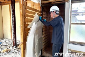 リノベーション工事で石膏ボードを剥がす男性